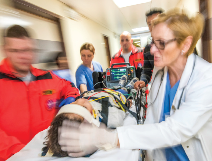 person being pushed through emergency hallway with doctors around them