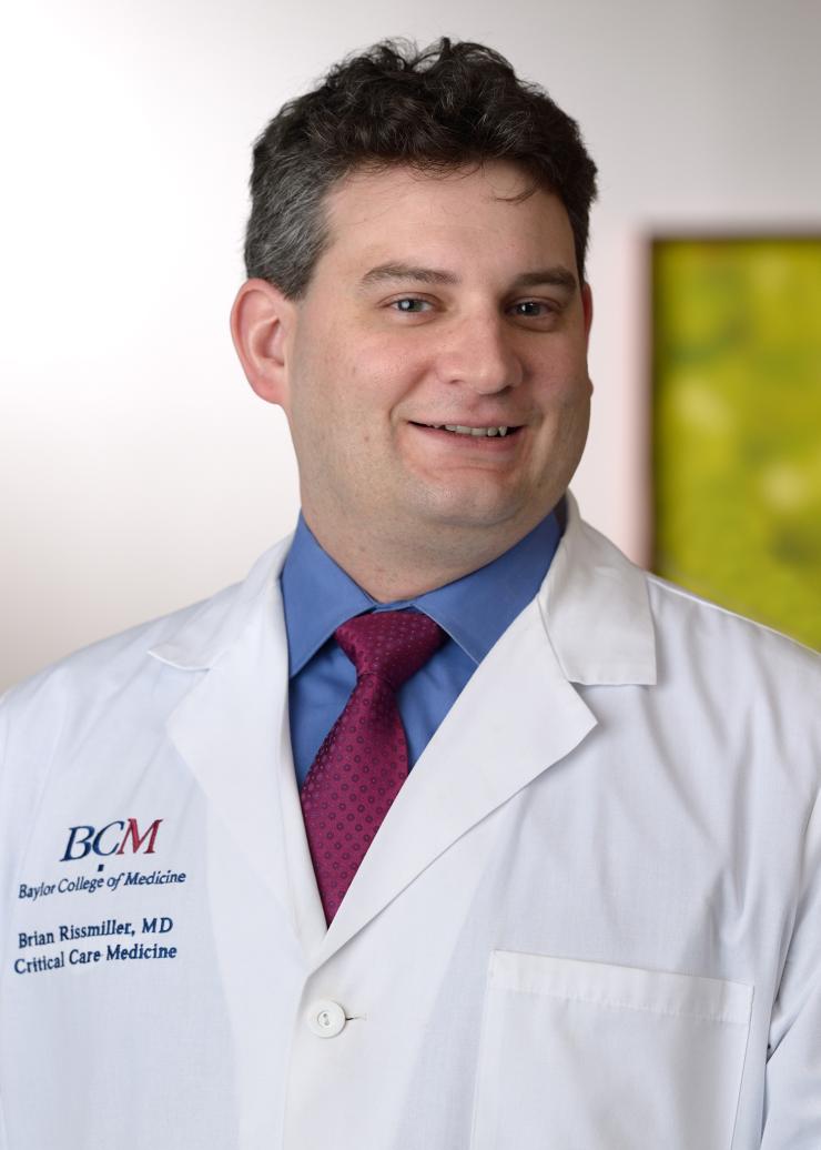 man in a white baylor college of medicine doctor coat smiling