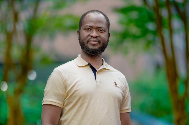 man in pale yellow polo shirt smiling lightly