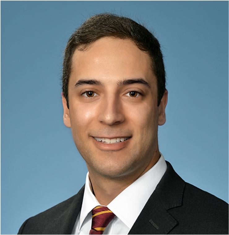 Man smiling in front of blue background