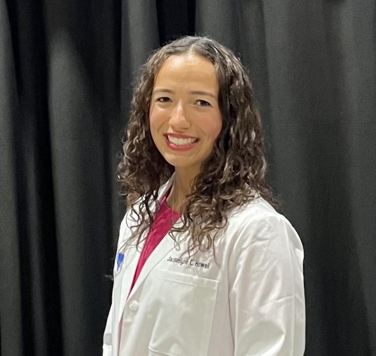 Woman smiling in front of grey background