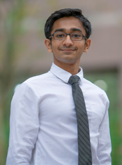 Man wearing a shirt and tie smiling outside