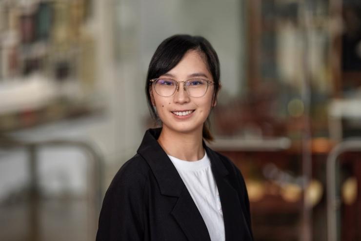 Woman smiling in front of grey background