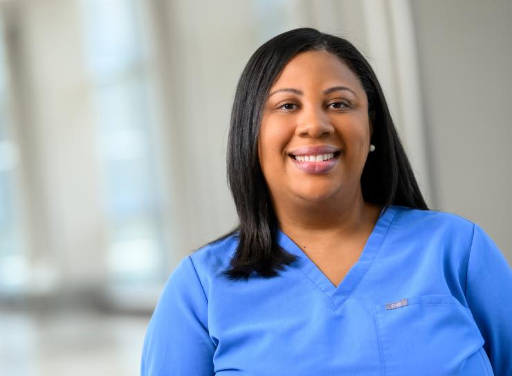woman in baby blue scrubs smiling