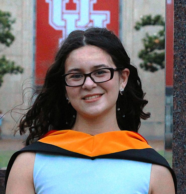 woman smiling in front of a University of Houston "UH" sign