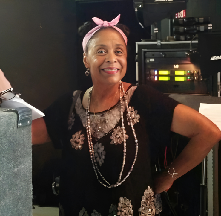 woman with a pink bow in her hair smiling