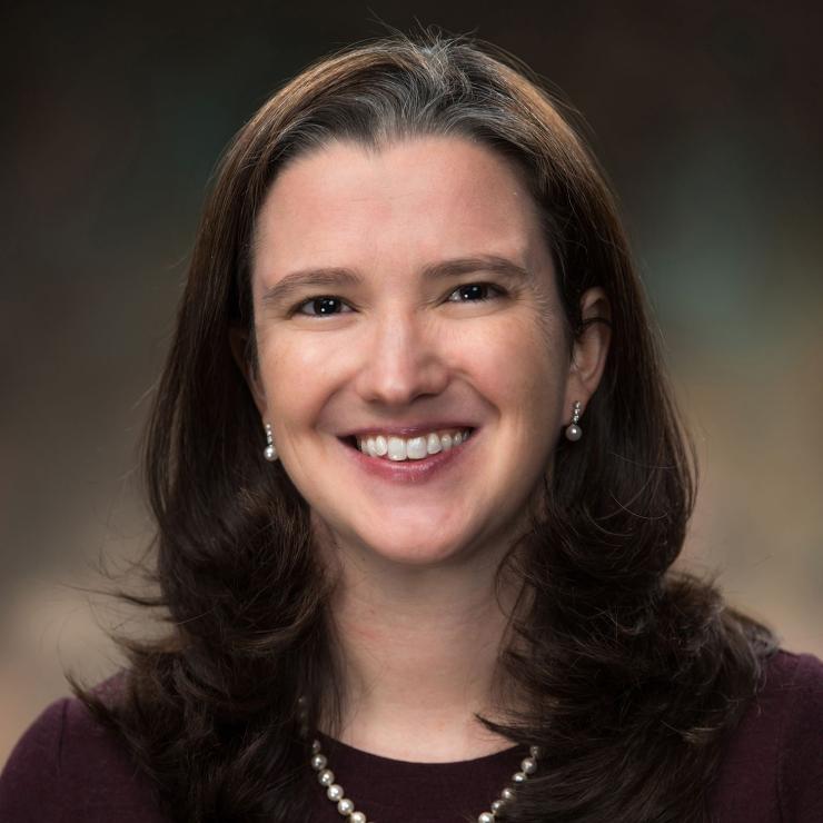 woman smiling in front of grey background