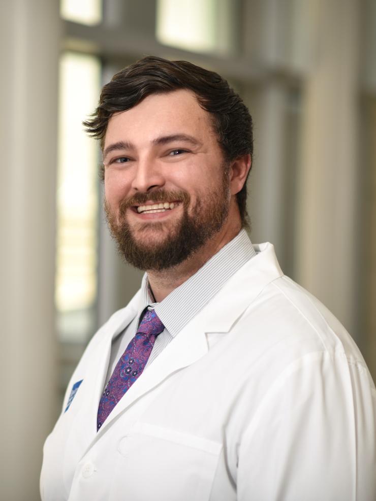 man with brown hair and a beard smiling