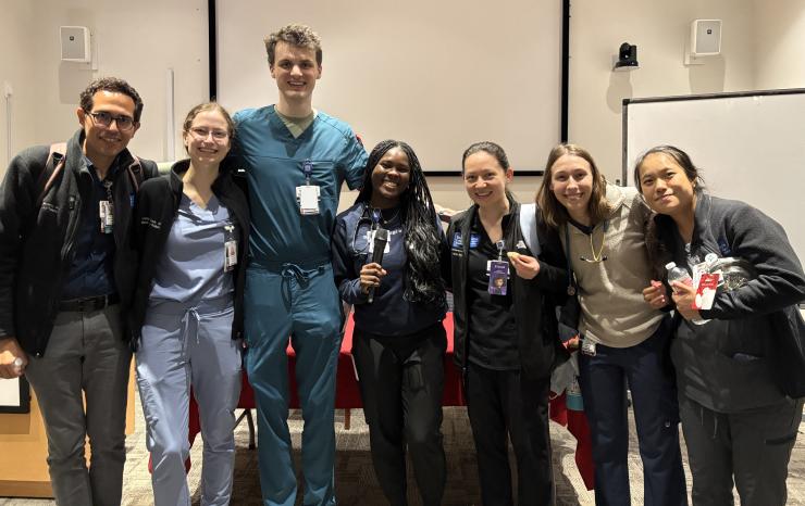 Seven people smiling, posed in a line