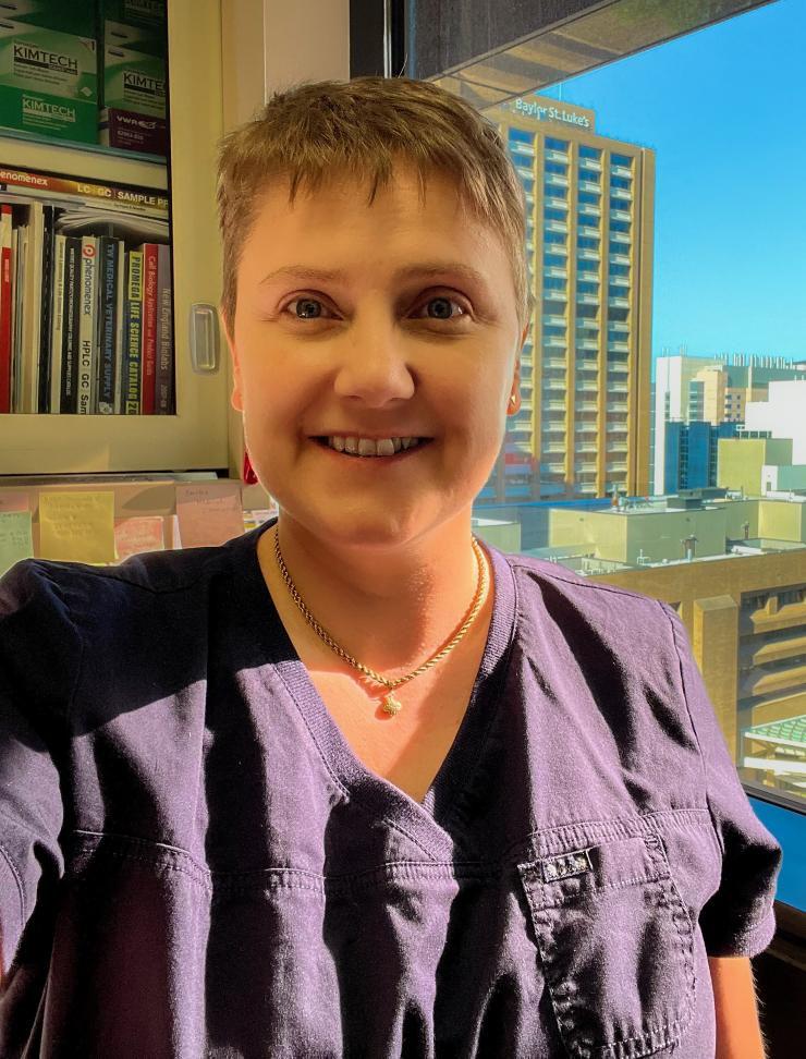 Woman smiling in front of a window overlooking the city