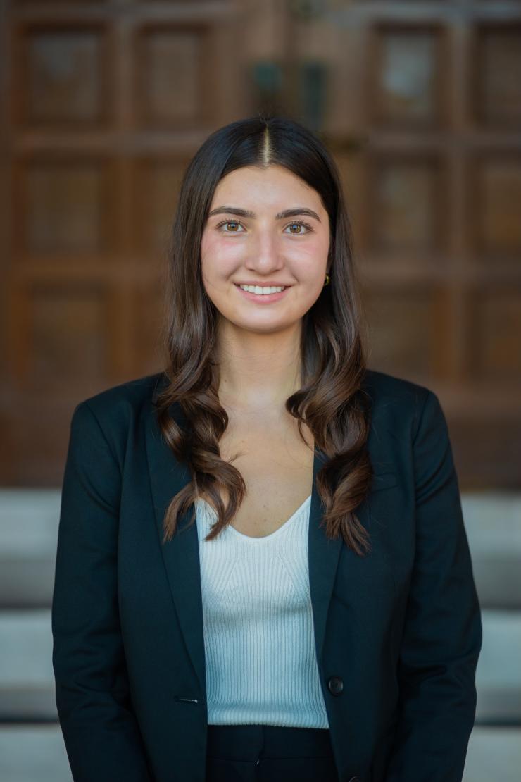 woman standing outside, in front of wooden doors