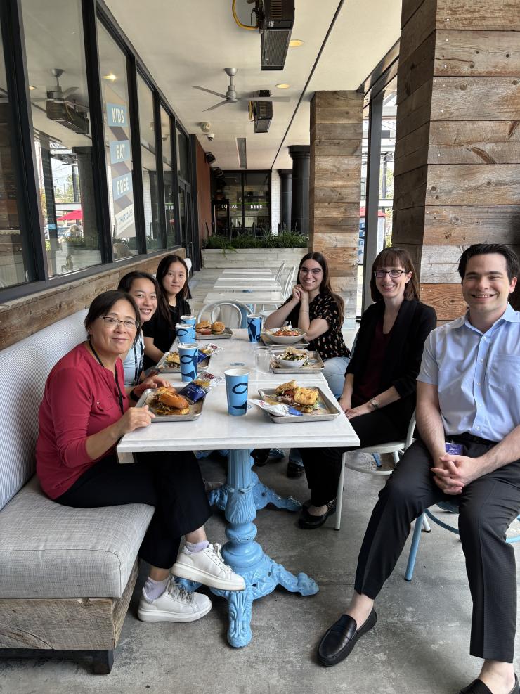 group of people smiling and having lunch together