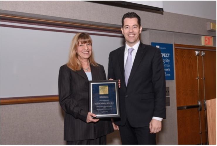 two people standing together smiling in business attire