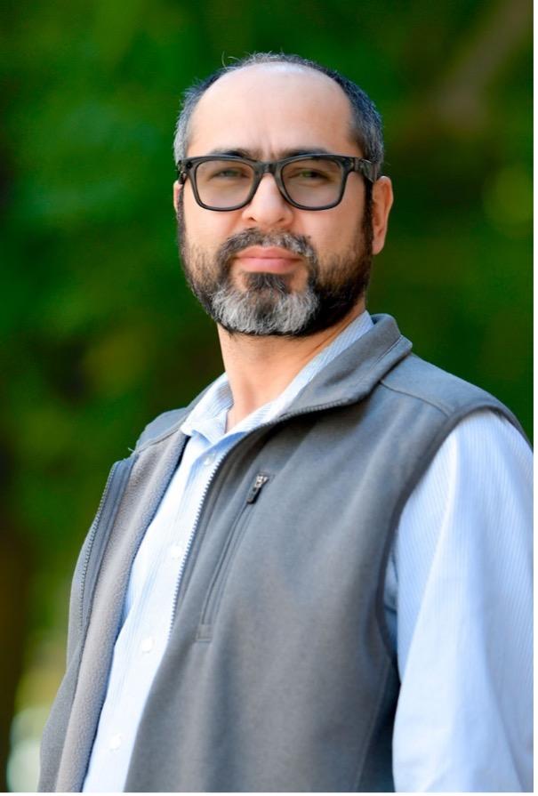 man with dark glasses on smiling lightly