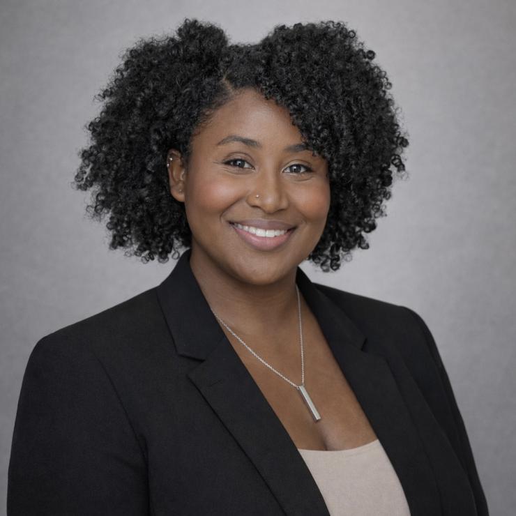 woman in a black blazer smiling