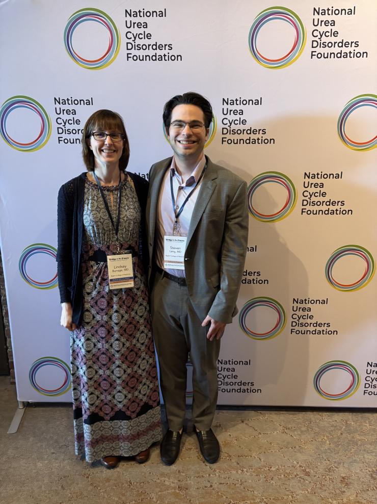 two people at a conference, smiling