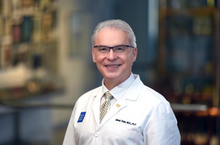 Jakub Tolar smiling and wearing and white doctor coat