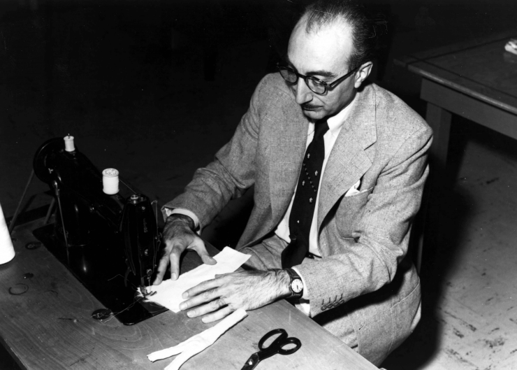 Dr. Michael E. DeBakey sits at his wife's sewing machine fashioning the first artificial arteries for cardiac bypass surgery made of Dacron.