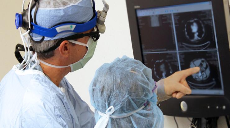 Dr. William Fisher discusses a CT scan with a colleagues during a pancreas resection.