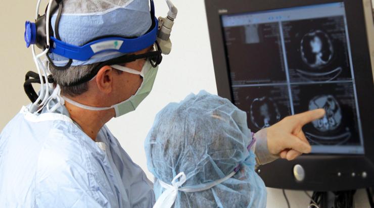 Dr. William Fisher discusses a CT scan with a colleagues during a pancreas resection.