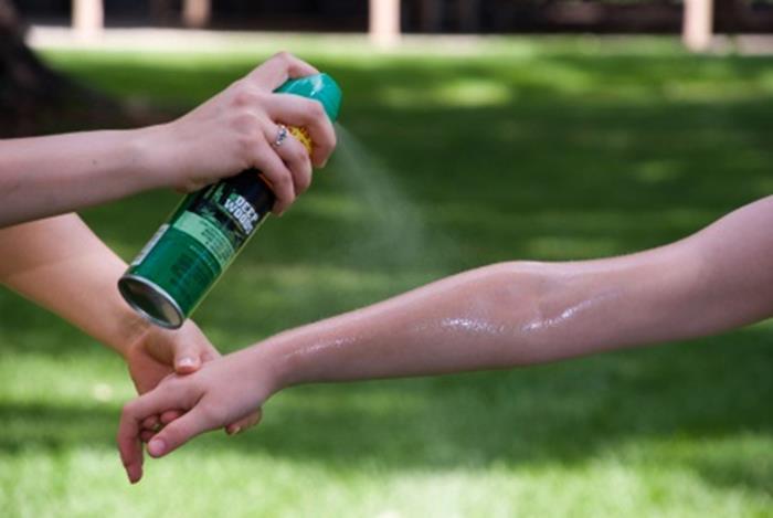 Applying mosquito repellant spray