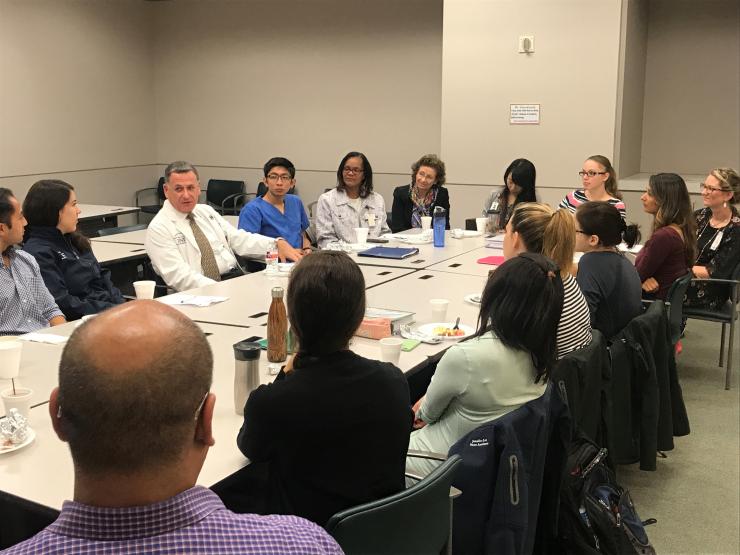 Photo of students, trainees, and faculty listening to Dr. James Walker at the August 2017 Tacos with Teachers