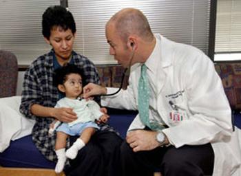 Dr. V. Reid Sutton with a young patient and his mother.