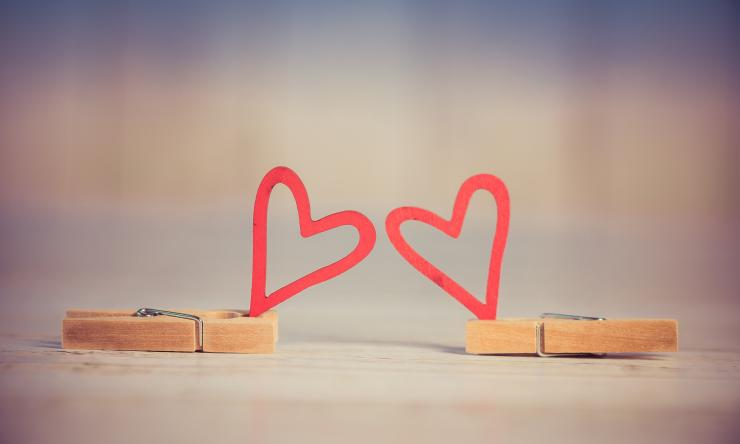 A pair of cartoon hearts held up by clothes pins.