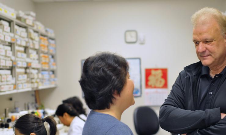 Dr. Hugo J. Bellen (right) talks with a colleague in a lab.