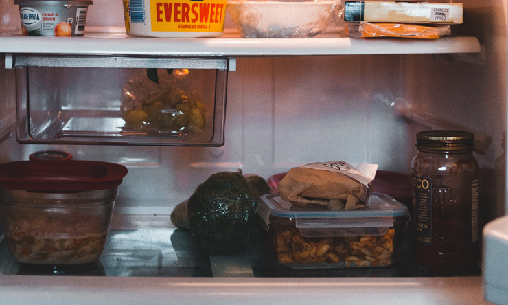 A refrigerator filled with leftover meals, vegetables and dairy products