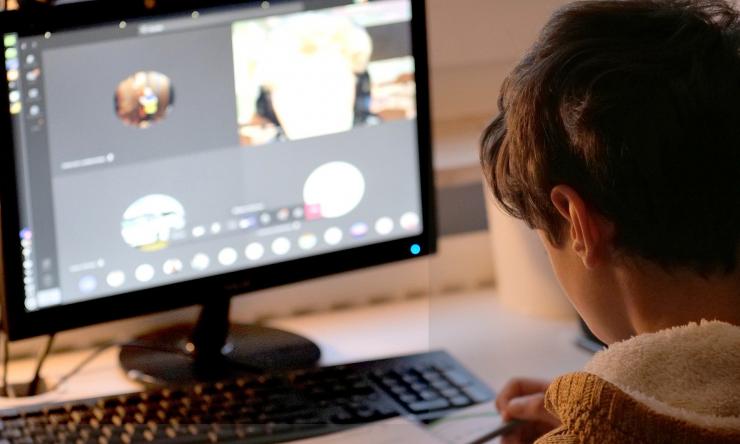 Child attending virtual school on computer