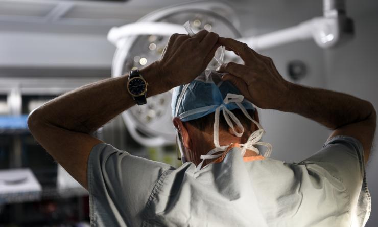 Dr. Marc Moon tying his mask in the OR