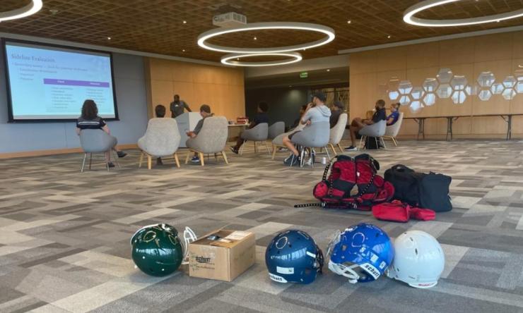 A group of orthopedic surgery faculty and staff watching a presentation about sports safety