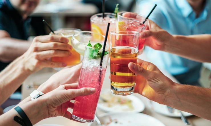 Group of people holds glasses of various alcoholic beverages