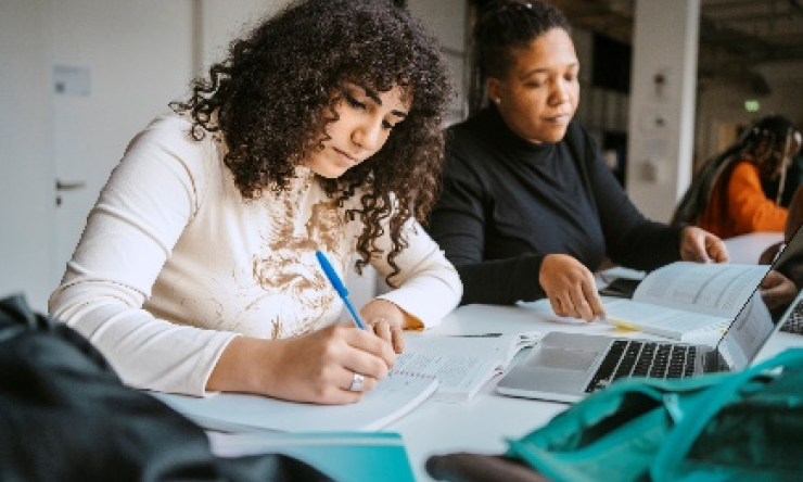 Three students sitting in a classroom setting