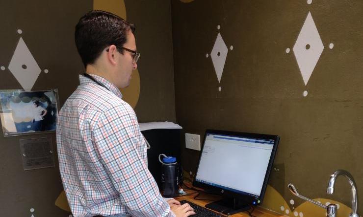 A person standing in front of a computer in a lab room