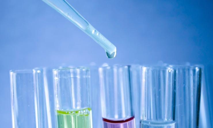 Close up of test tube filled with colored liquid. 