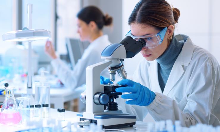 Female looking through a microscope