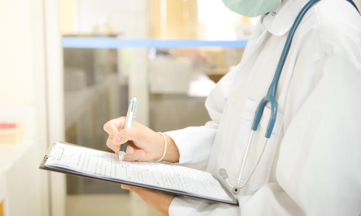 Photo of doctor writing on pad