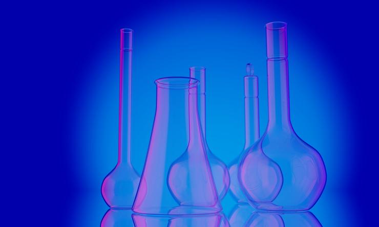 Photo of different sized beakers with blue and pink lighting, represents a general idea of lab work.