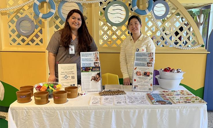 2 women standing behind a table