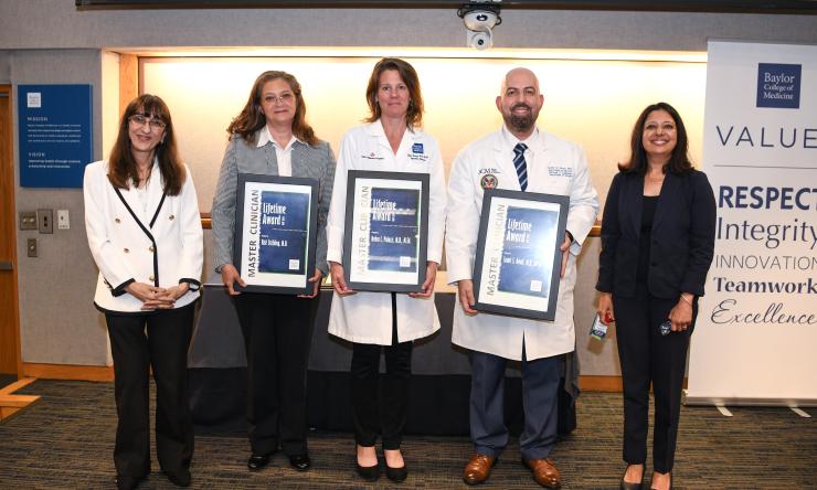 group of people holding award plaques smiling