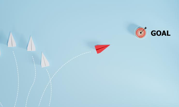 paper airplanes with one going towards a target