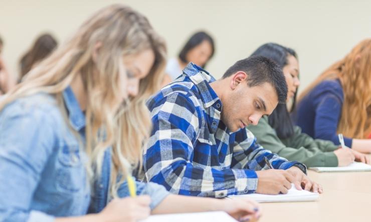 A few students studying carefully in a classroom.
