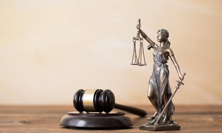 themis statue on wooden table with a gavel