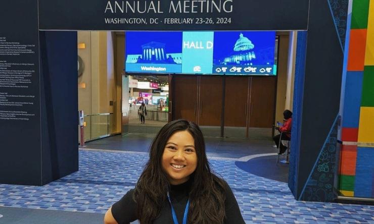 woman standing in front of Annual Meeting signage