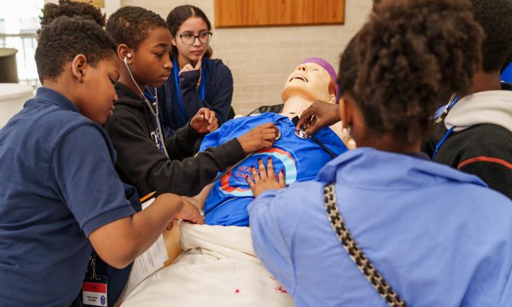 Students from Ryan examine a medical dummy during an open house event