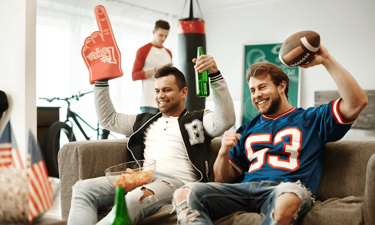 Football fans cheering in their living room. 