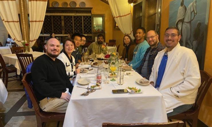 group of people sitting around a dinner table