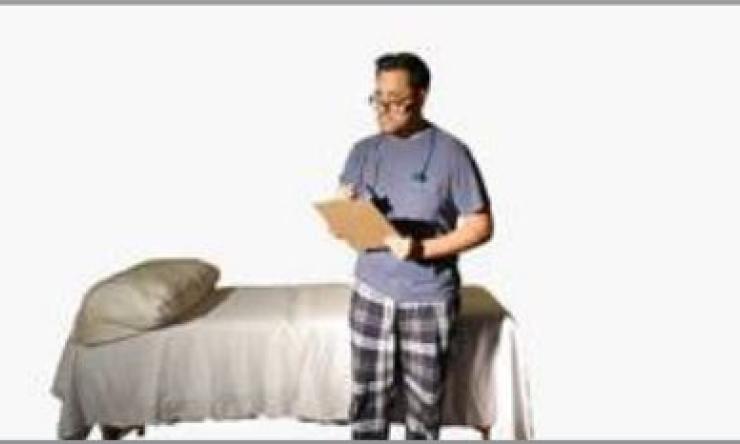 man standing next to a bed with a clipboard in his hands